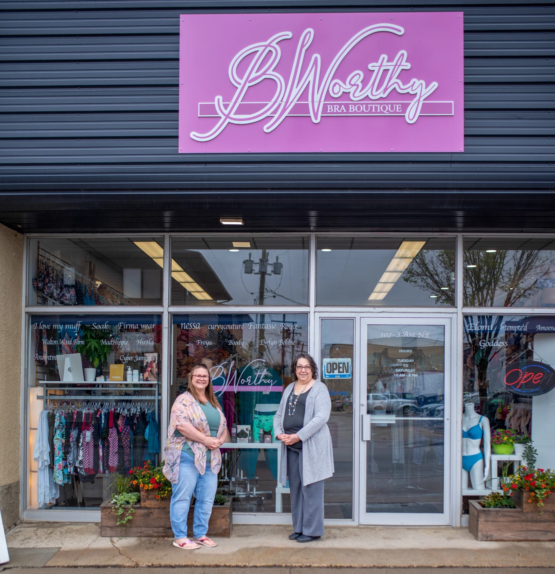 B Worthy Bra Boutique storefront with two people standing outside and lingerie displays.
