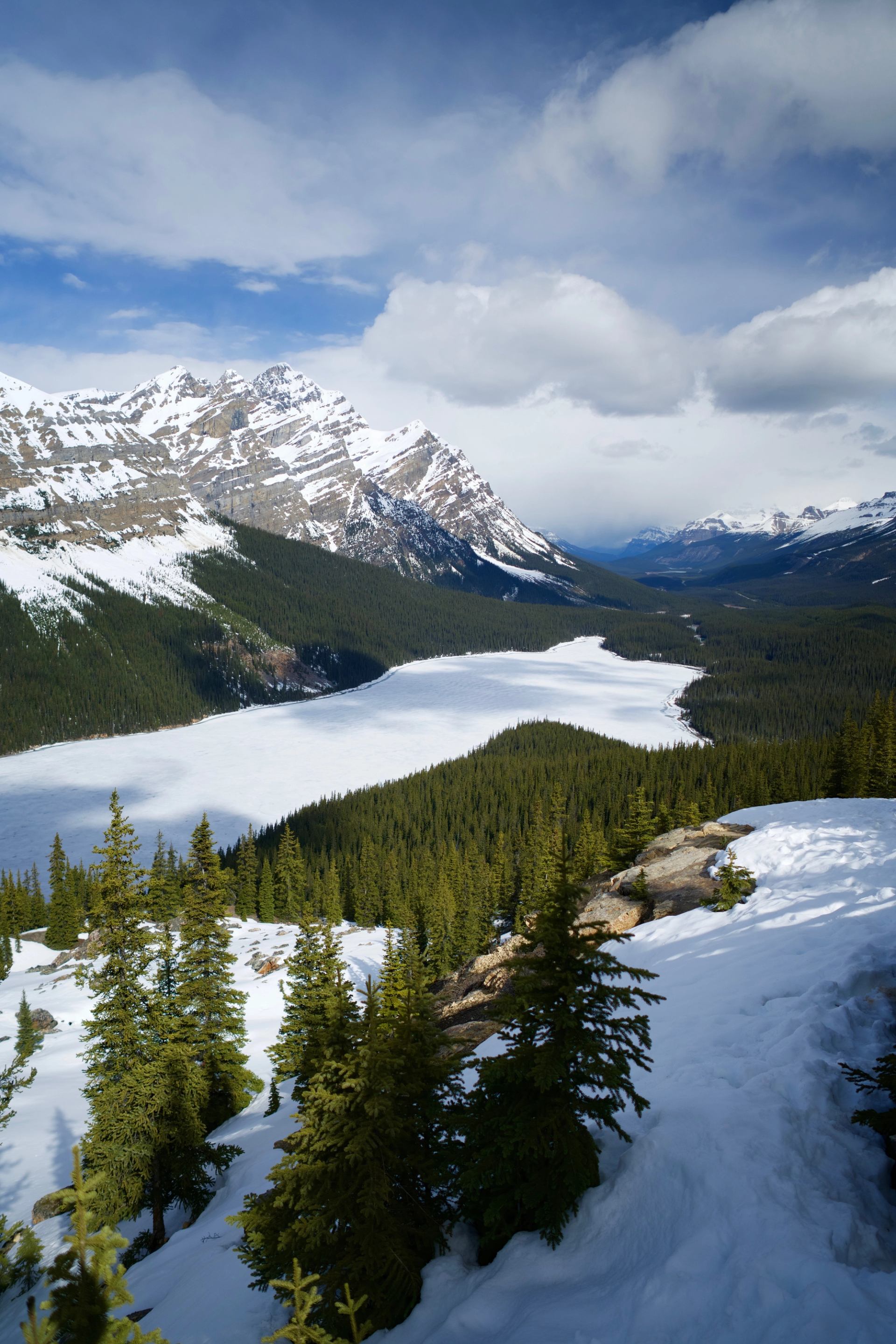 Snowy peaks and frozen lake along Icefields Parkway in the Canadian Rockies.