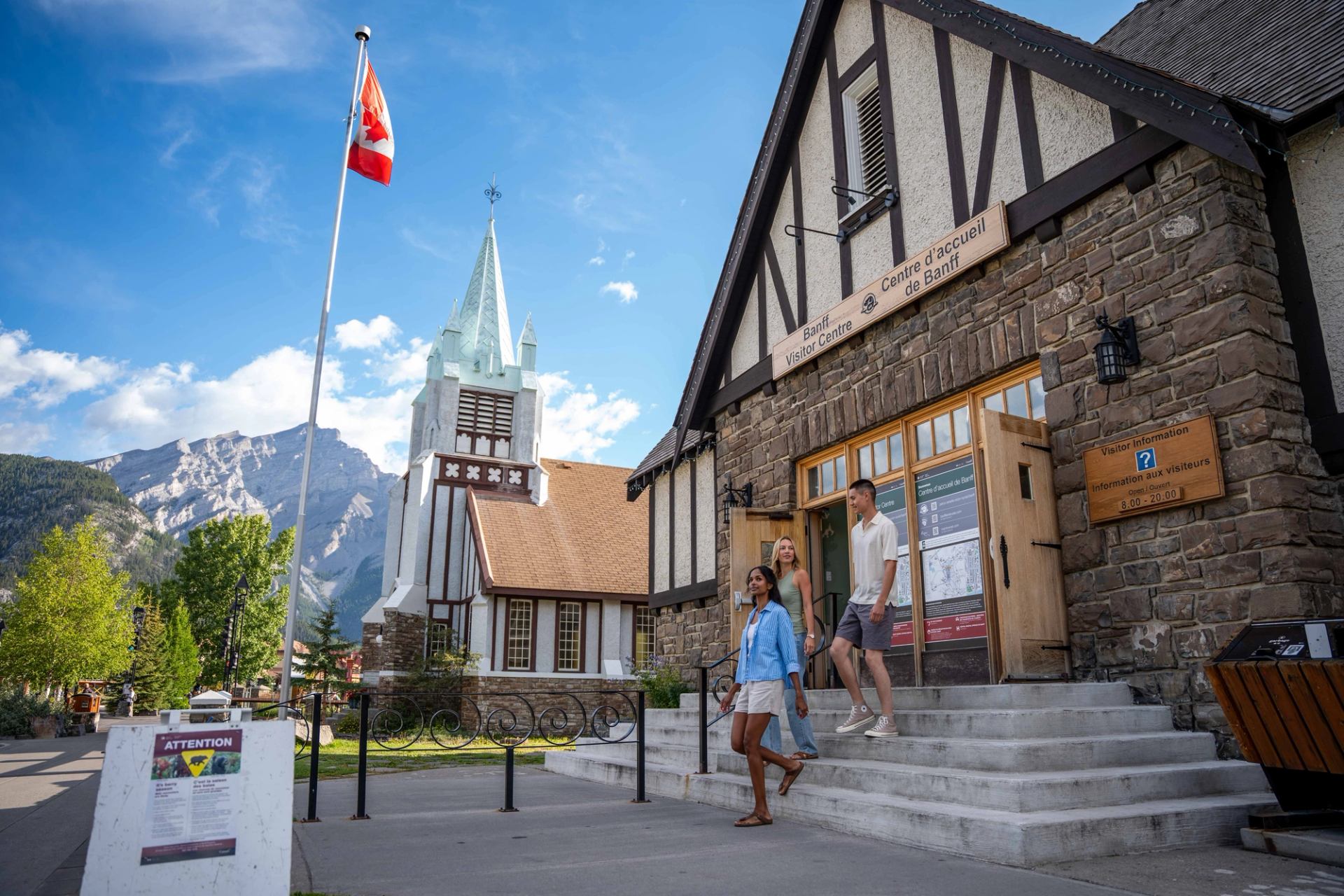 A group of people exiting the Banff Visitor Centre