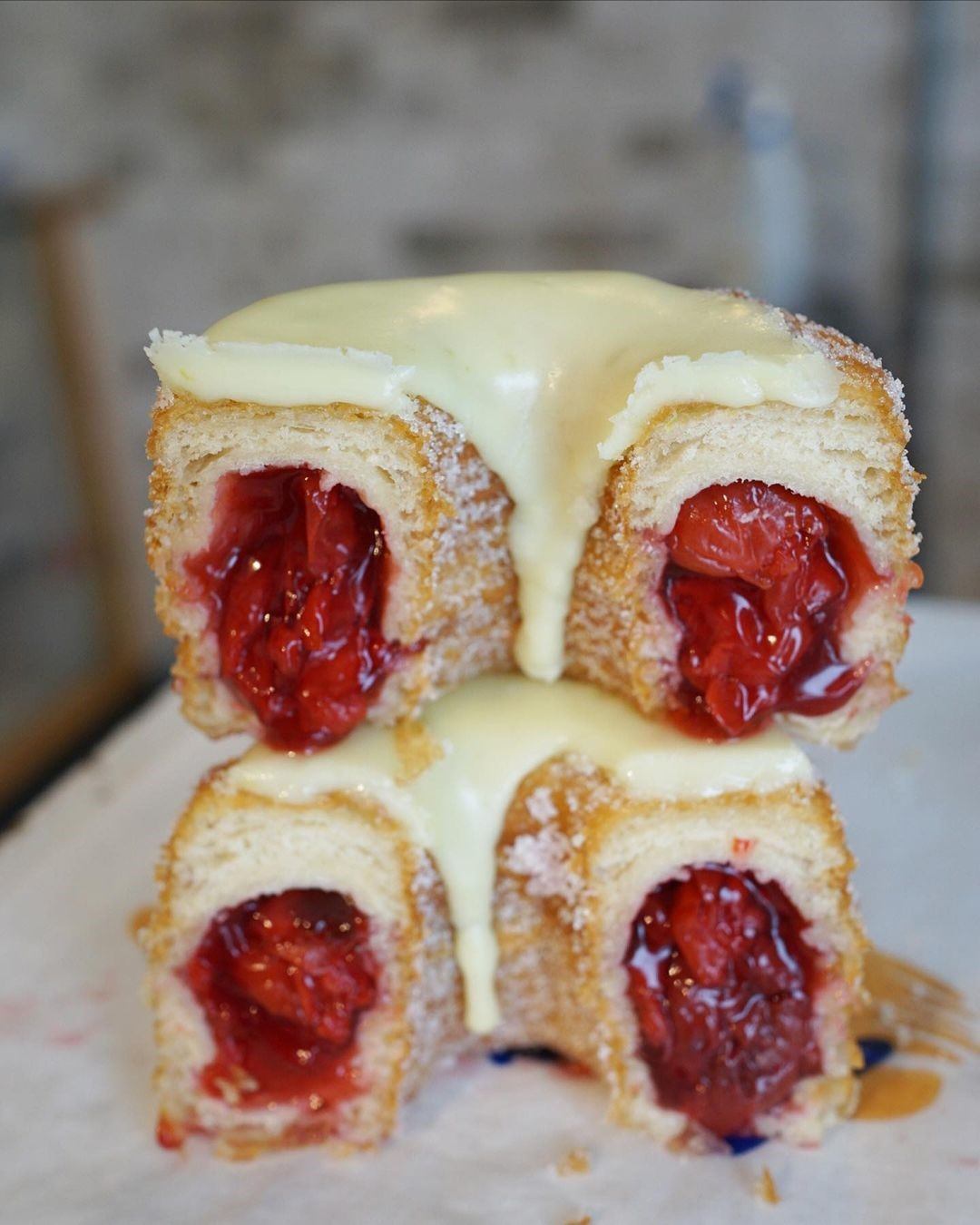 Stack of fruit-filled pastries topped with creamy white drizzle.