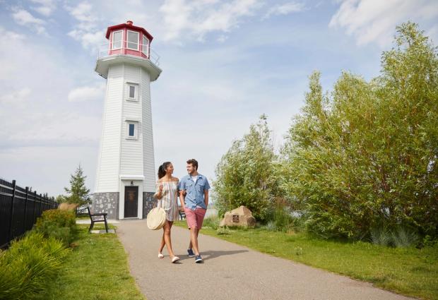 A couple walk in front of the lighthouse at Sylvan Lake.