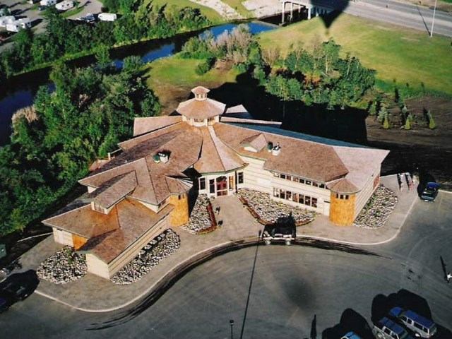 Aerial view of a multi-roof building surrounded by trees and greenery.