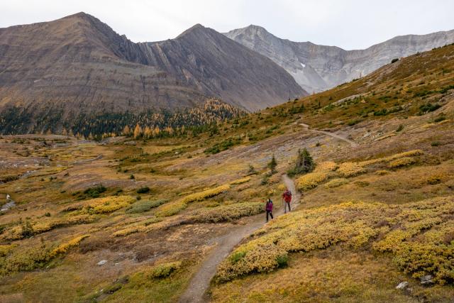 Wide shot of couple hiking on a trail in Ptarmigan Cirque.