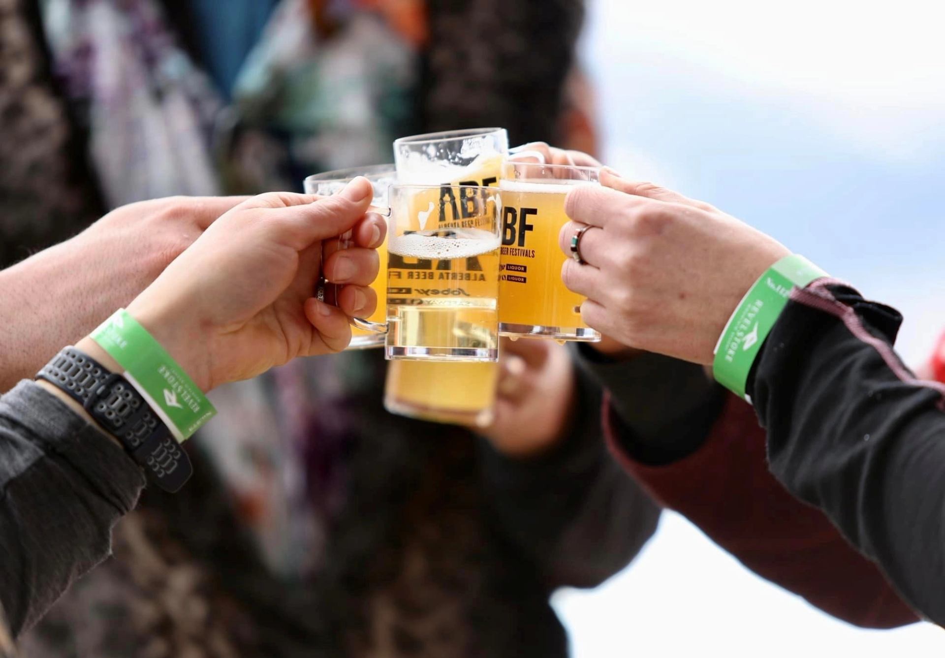Four beer glasses clinked in a toast at Calgary International Beerfest.