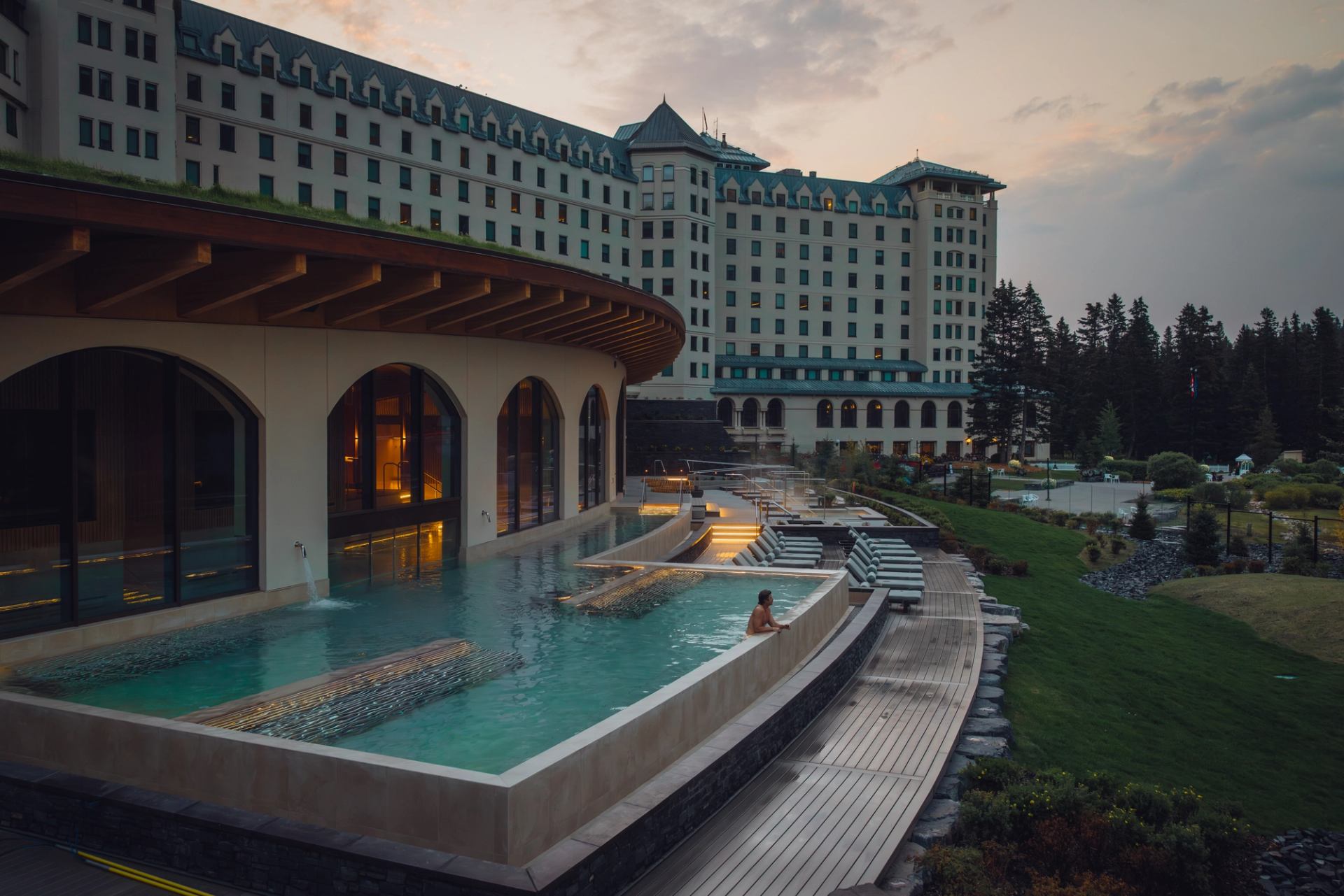 A man looks out from the pool of a luxury mountain spa in the Canadian Rockies.