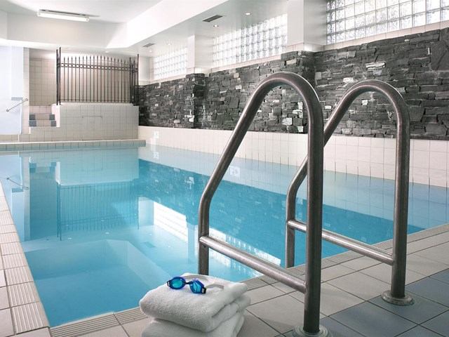 Indoor pool with white towels and goggles on the edge at Four Points by Sheraton.