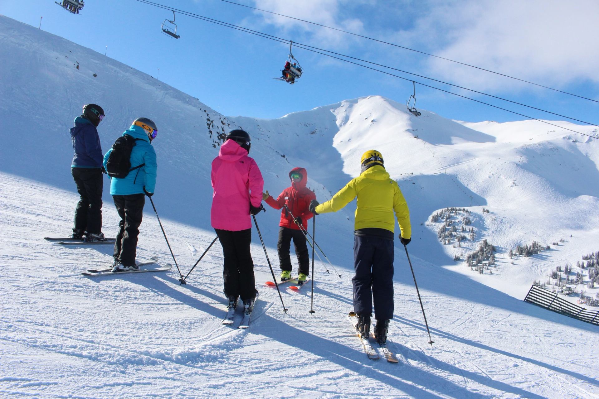 A group of skiers being instructed at Marmot Basin with the peak and chairlift in the background.