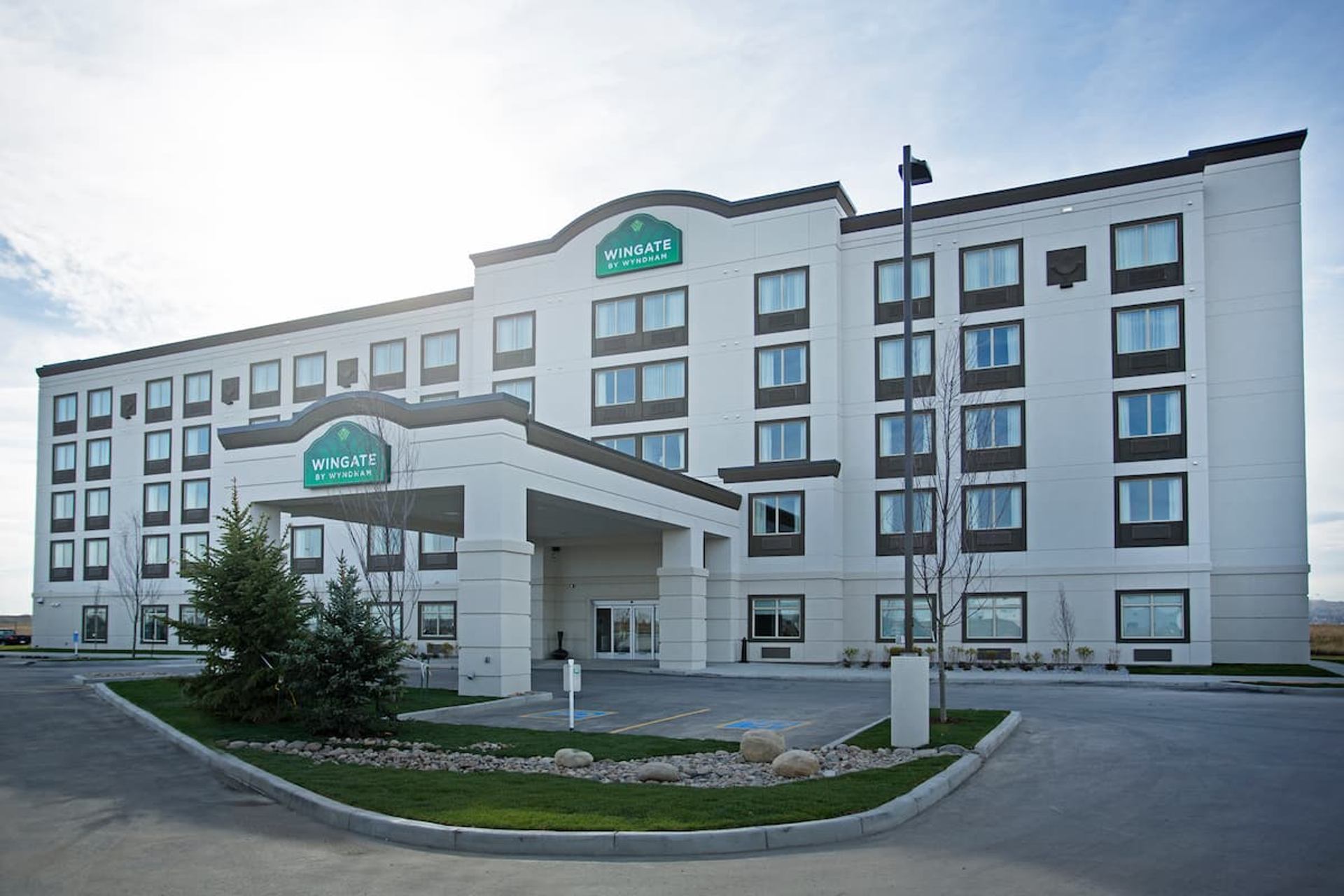 Exterior of Wingate by Wyndham Calgary Airport hotel with modern facade and entrance.