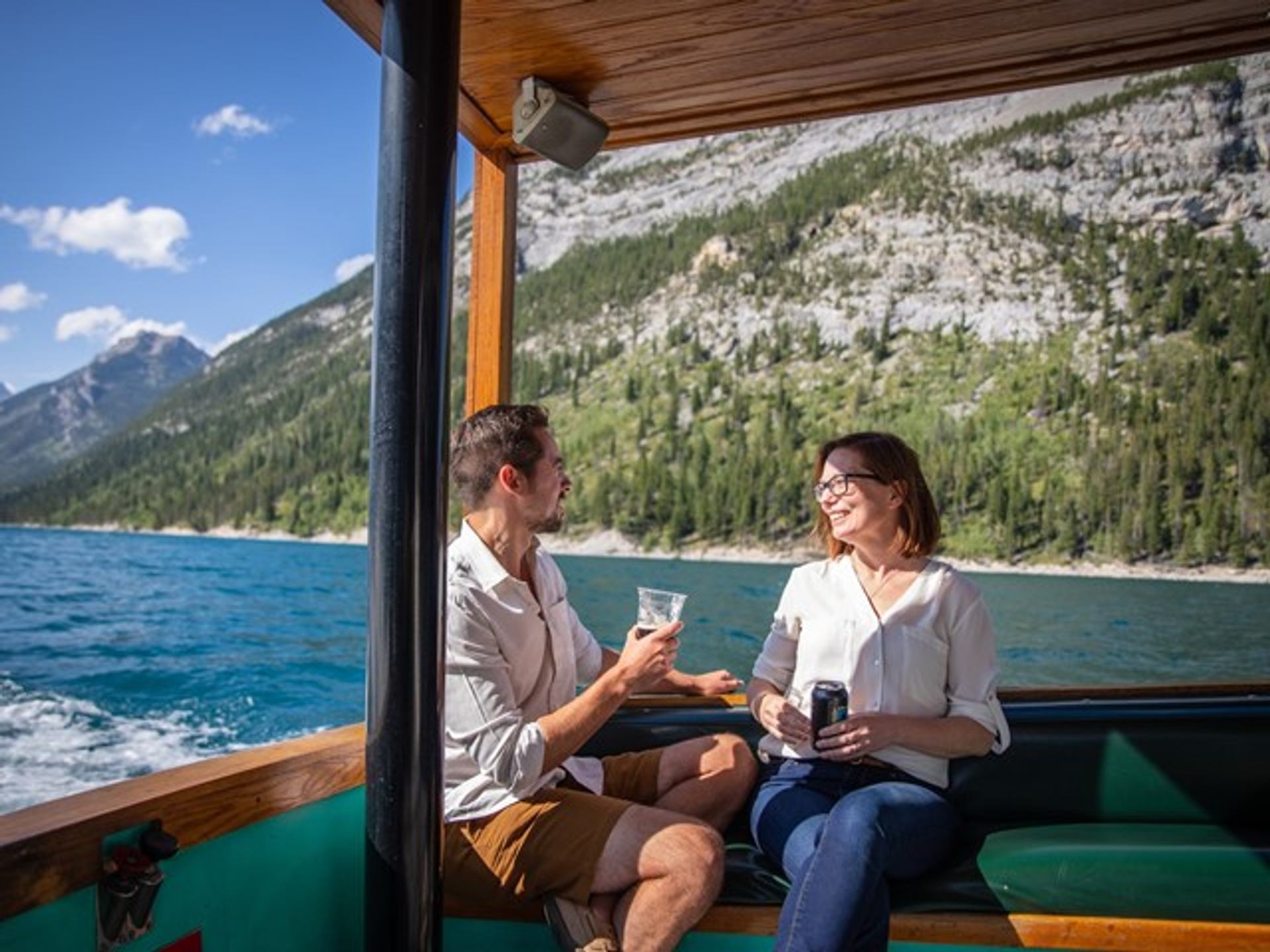 Couple enjoying a drink on a Lake Minnewanka Cruise.