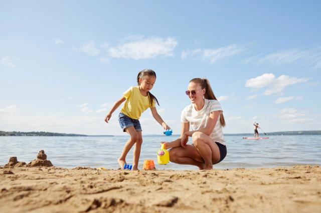 A mom and young daughter play in the sand at Sylvan Lake.