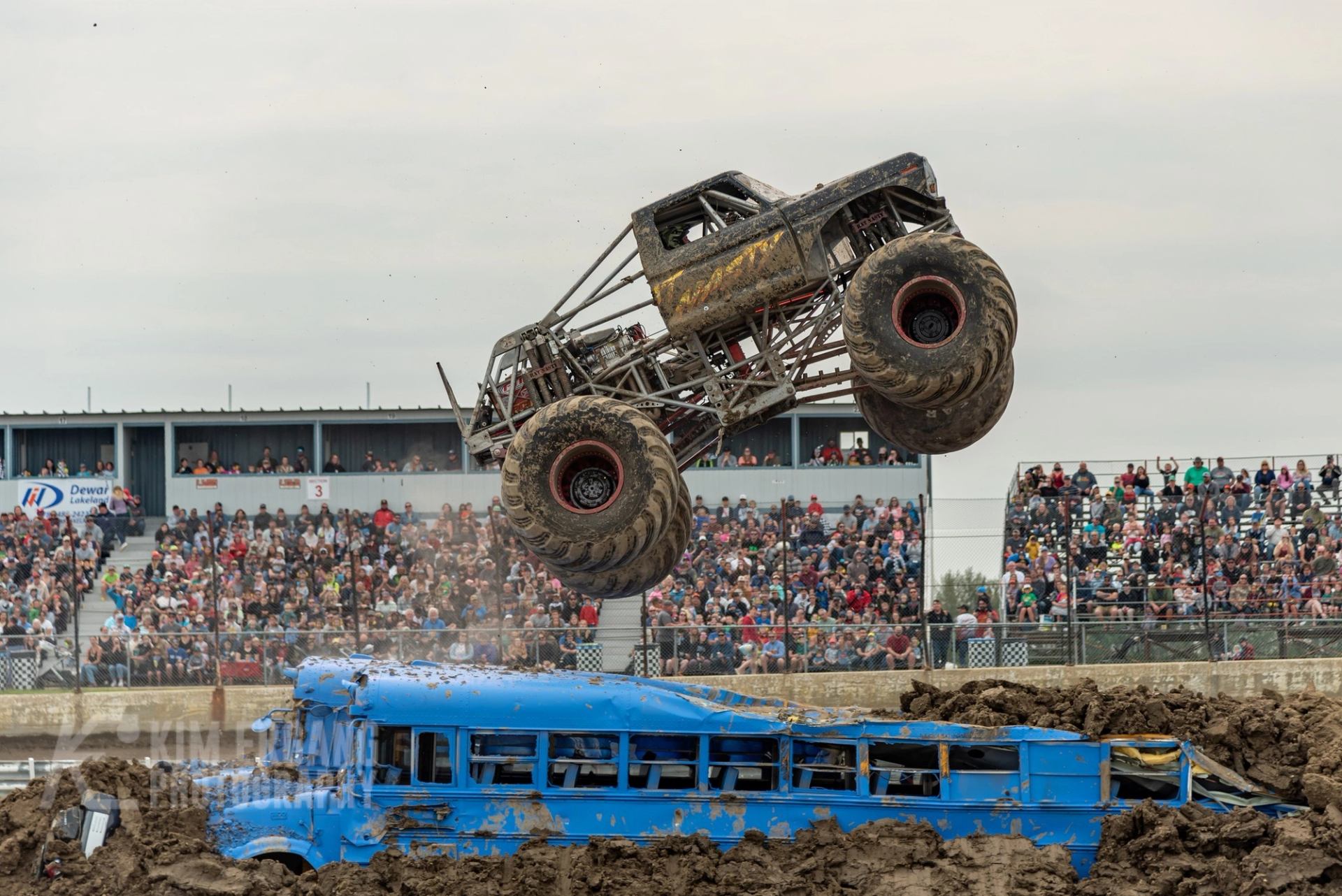 A monster truck jumping over a bus