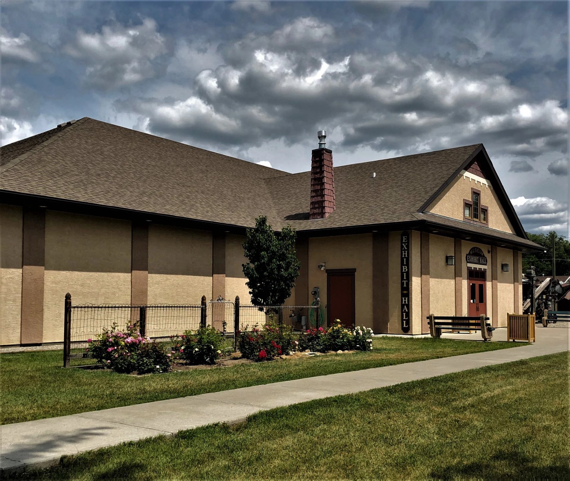 Historic train station with wooden deck and benches in front.