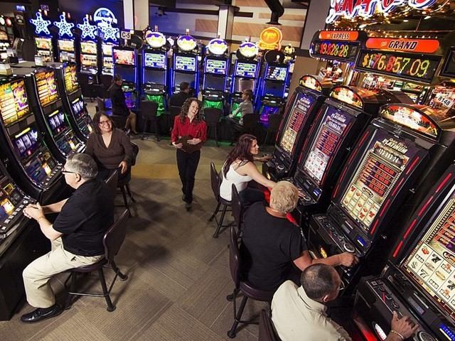 Guests playing slot machines in a bright casino gaming area