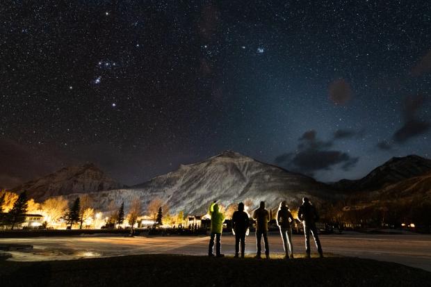 A group enjoys the winter night sky on the Starry Skies Townsite Stroll Tour.