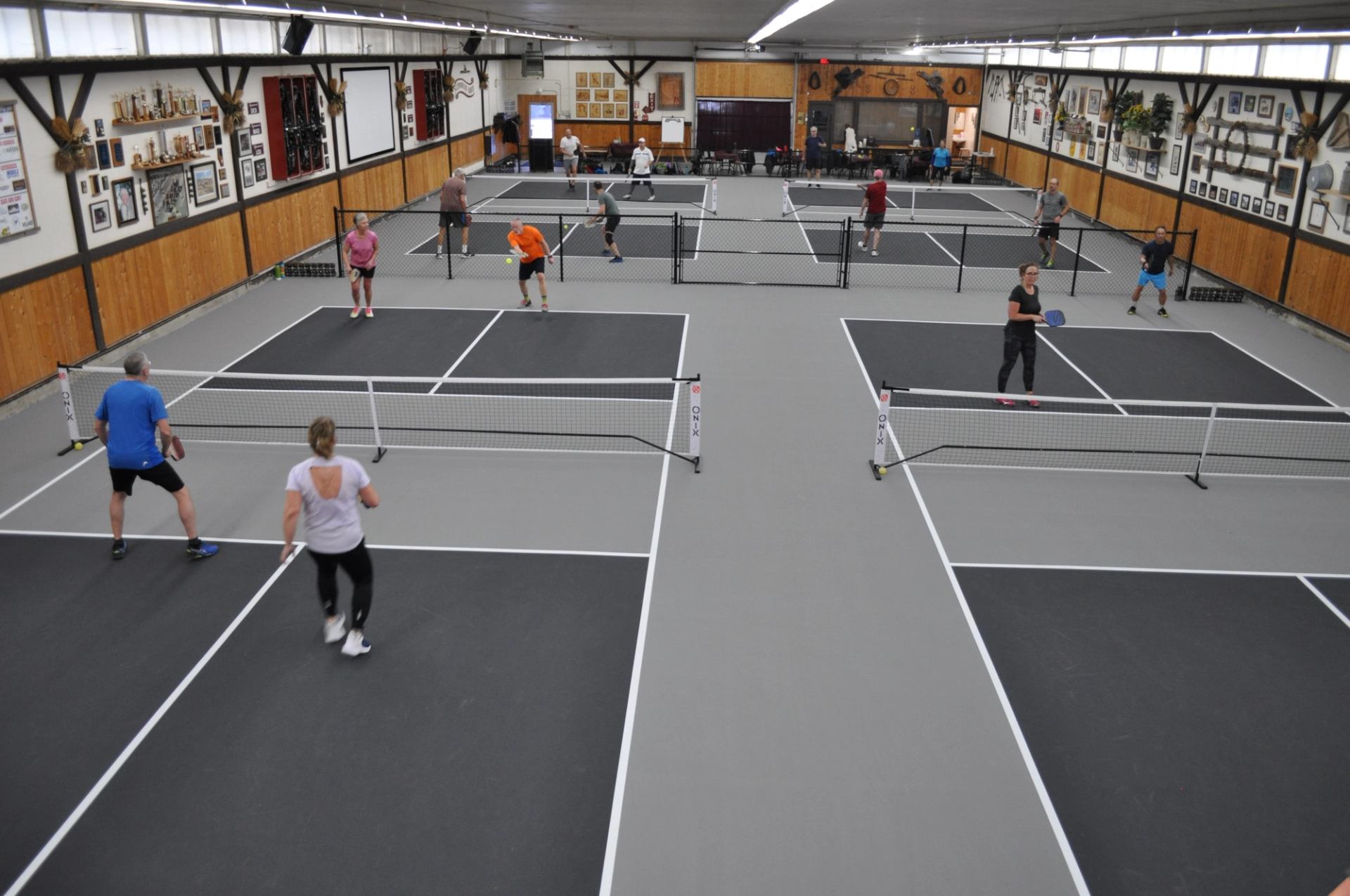 Indoor pickleball courts with players in action at Lynnwood Ranch.
