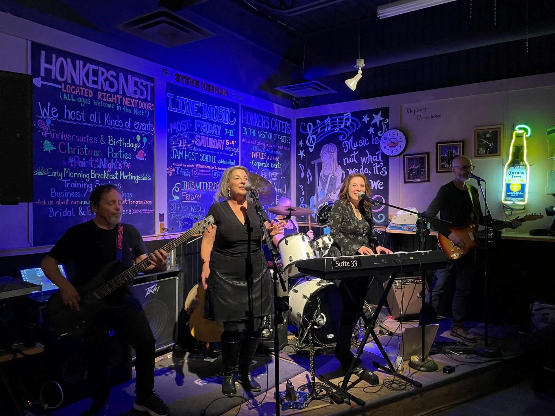 Band playing on stage at Honkers Pub with instruments and neon decor
