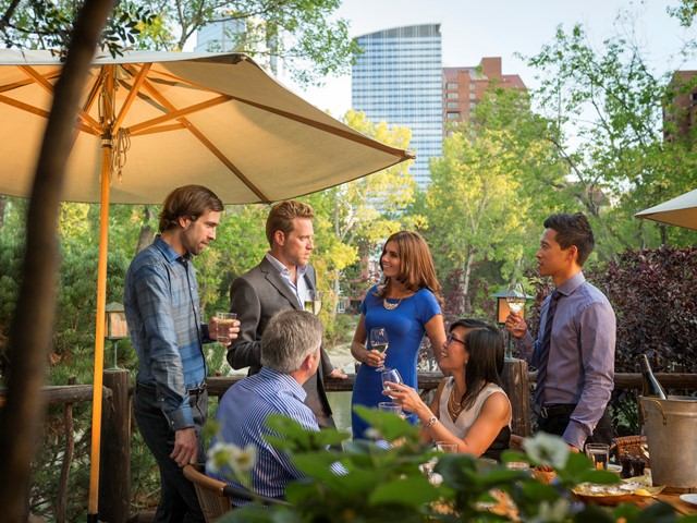 Group of business people enjoying drinks on a patio in Prince's Island Park.