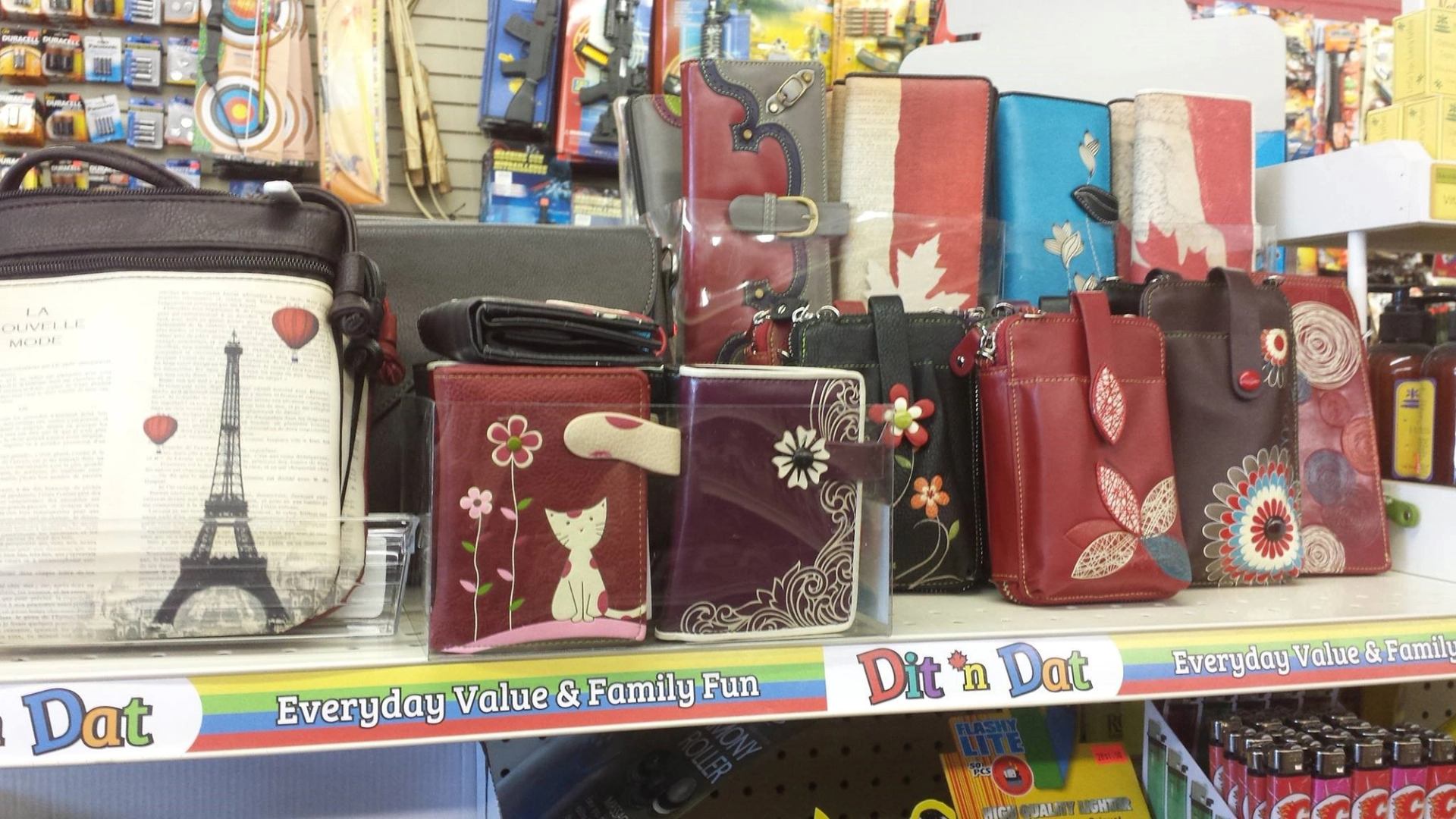 Leather wallets and coin purses with Canadian flags and floral designs on a store display.