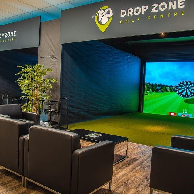 Comfortable lounge seating facing golf simulator screen
