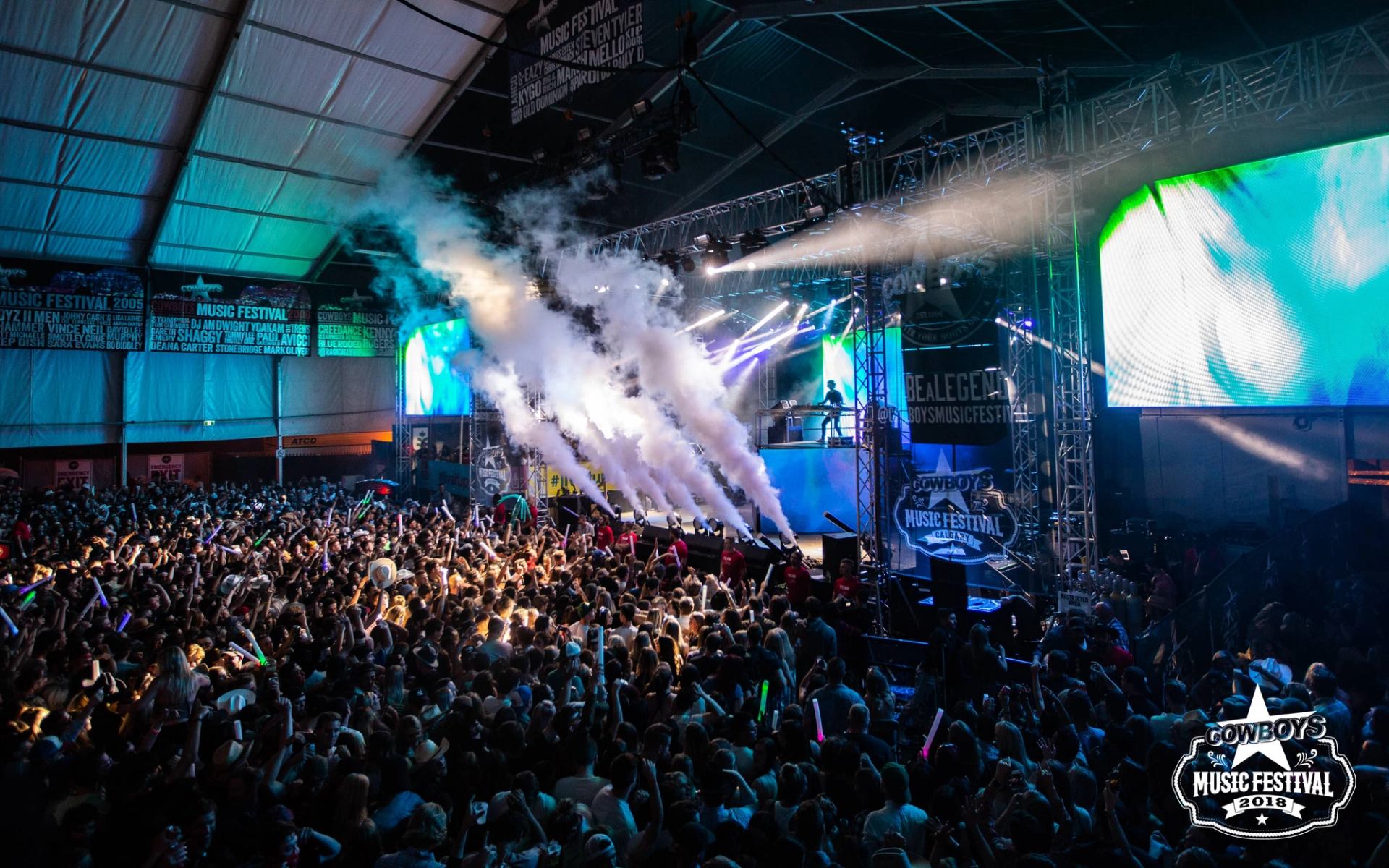 Dry ice shoots over a crowd at an indoor music event during the Calgary Stampede.
