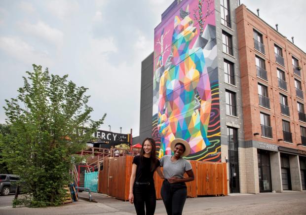 Two women in front of art mural along Whyte Avenue.