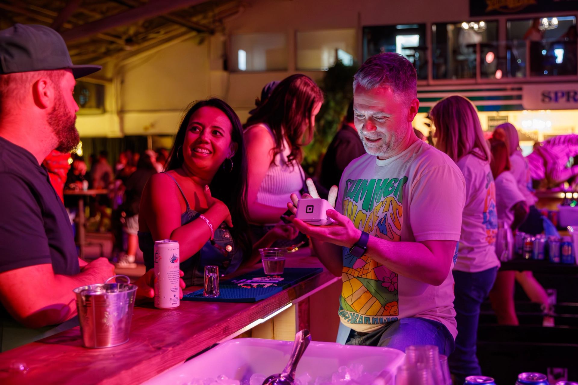 People gathered at a bar counter ordering drinks during the concert