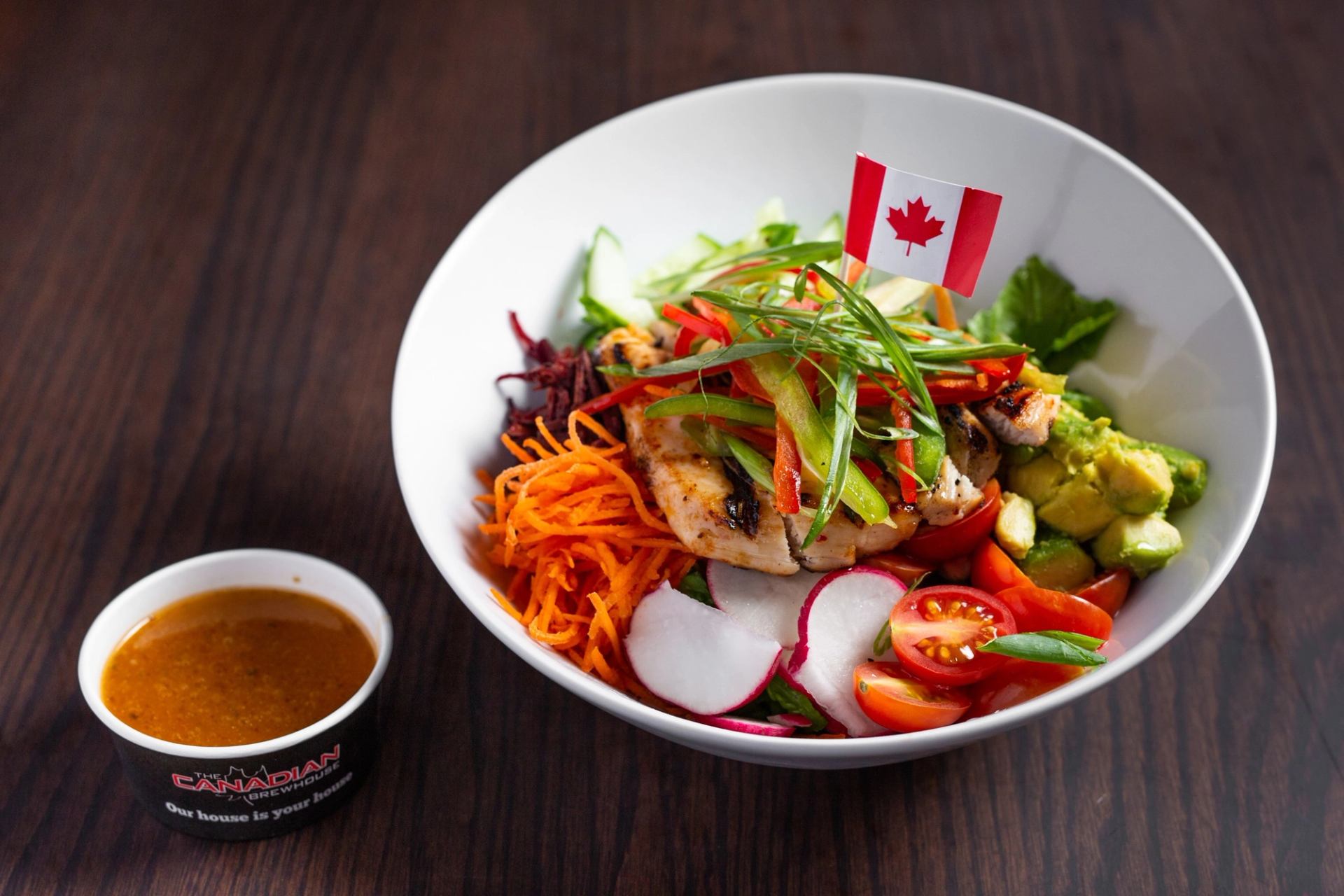 Vibrant salad bowl with grilled chicken, veggies, and Canadian flag garnish