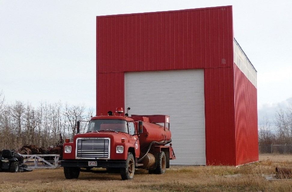 Museum's fire-truck in front of stage 1 of fire-hall building.