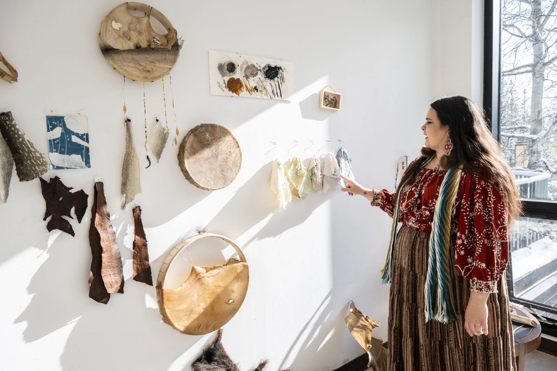 Lady stood by a wall with art hanging on the wall.
