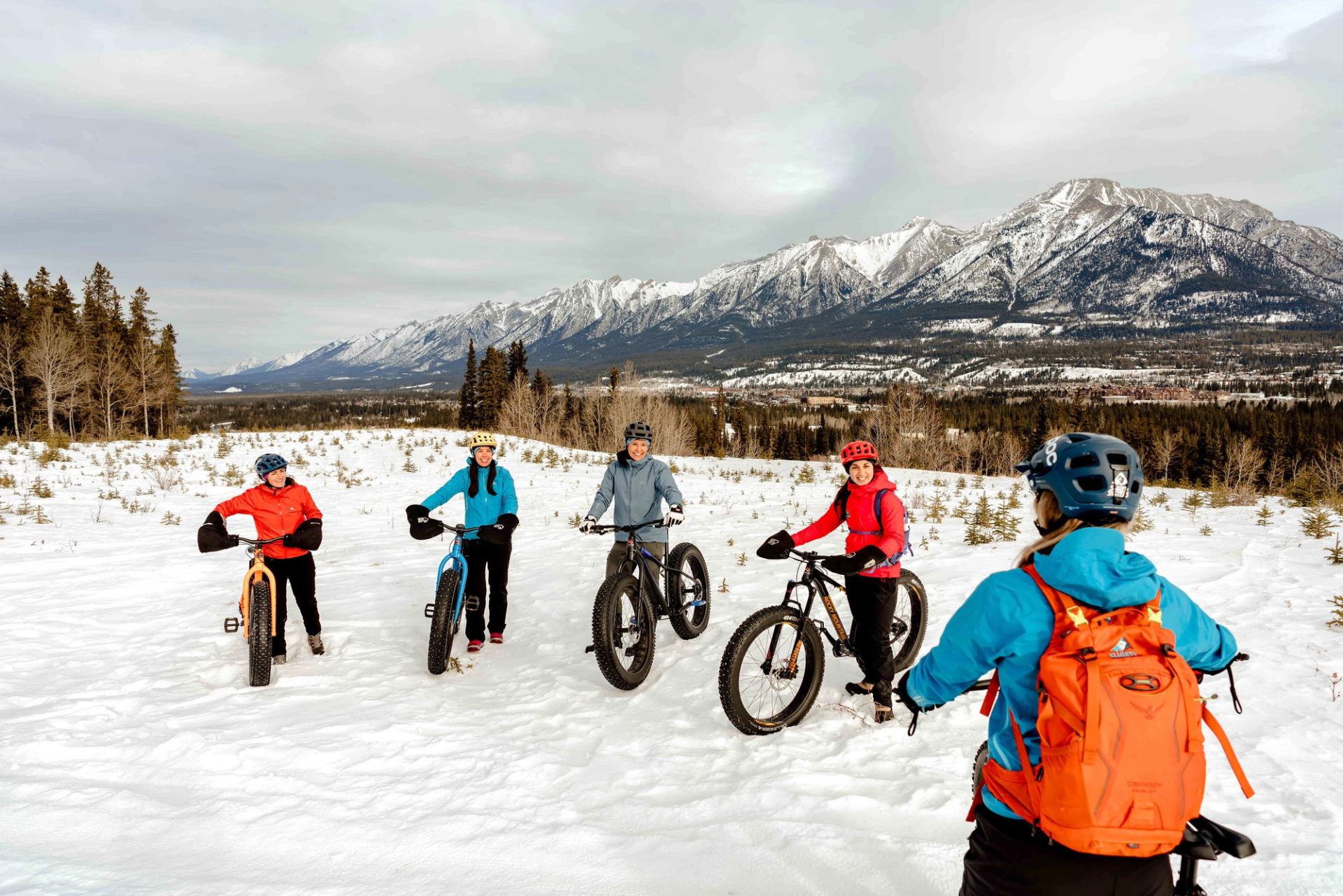 A group of people on a fatbiking tour stop for instruction in Kananaskis Country