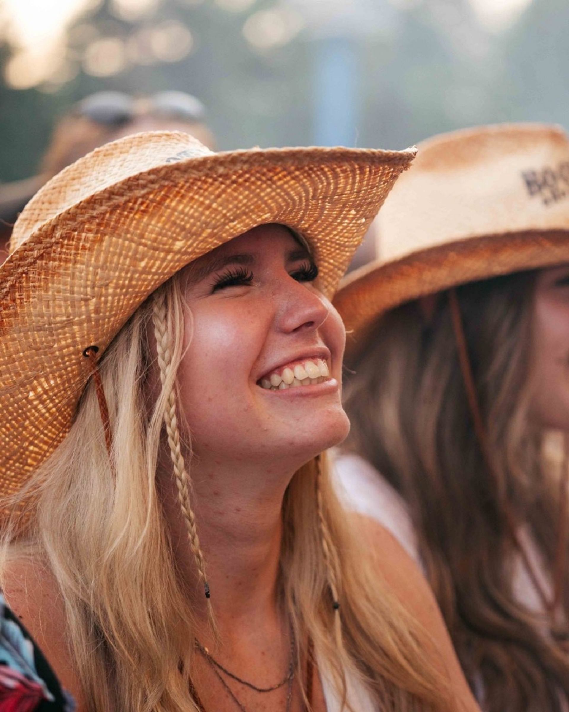 Person in a cowboy hat enjoying the festival alongside others.