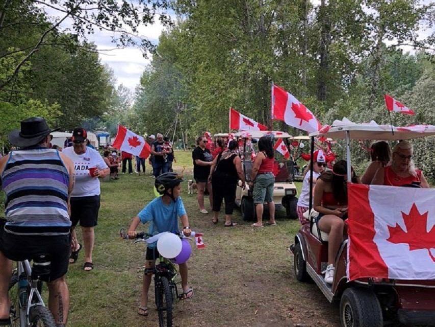 People celebrate Canada Day with flags, bikes, and carts