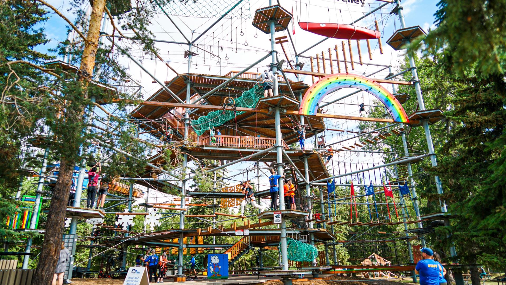 Snow Valley's large climbing structure with a range of colourful obstacles and people climbing.