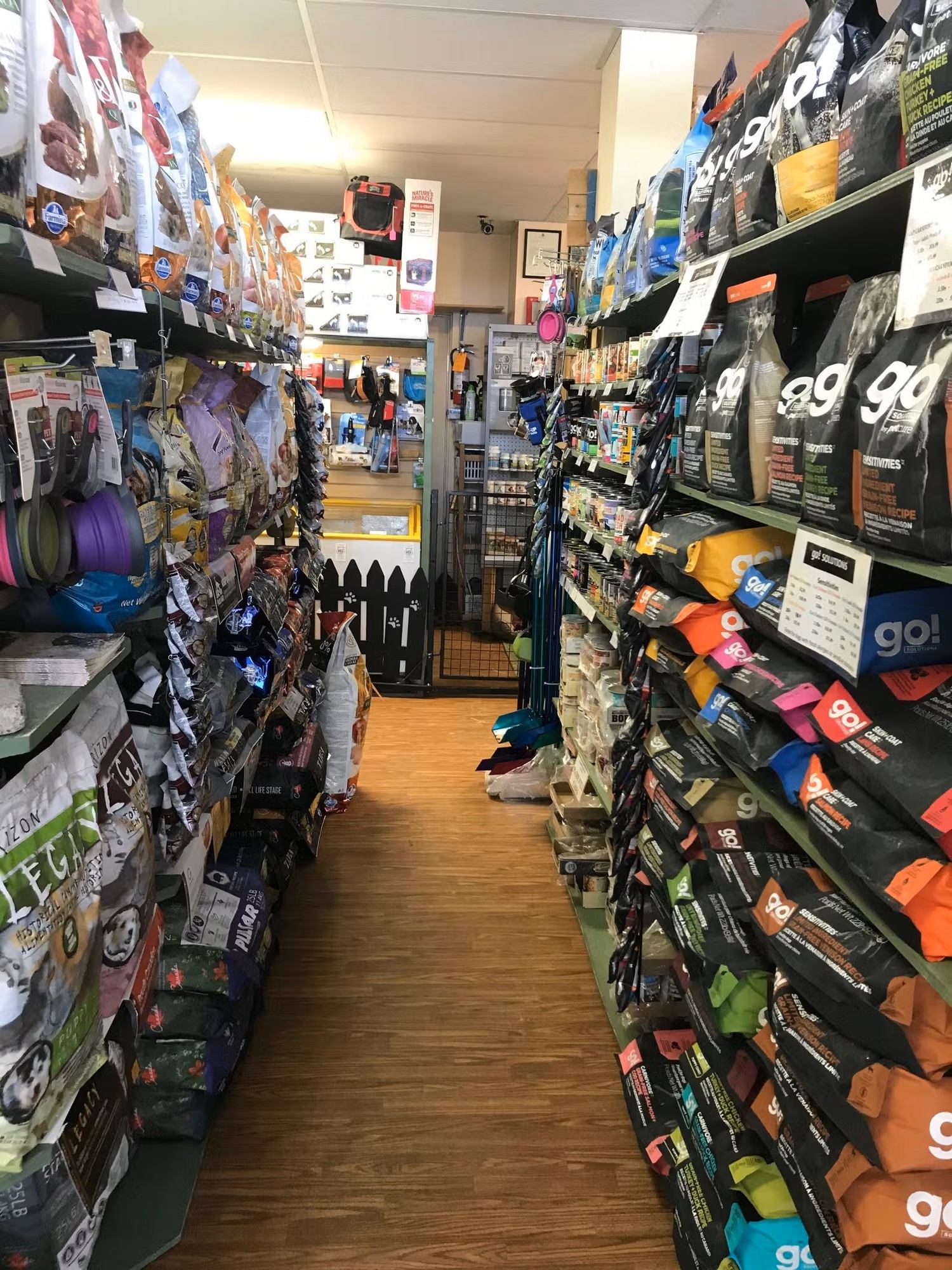 Aisle lined with shelves full of assorted pet food bags at Chinook Windz store.