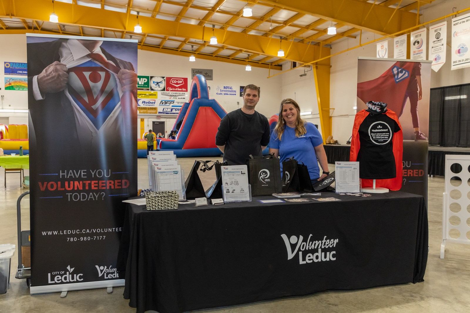 A Volunteer Leduc booth showcases information and merchandise inside an event hall.