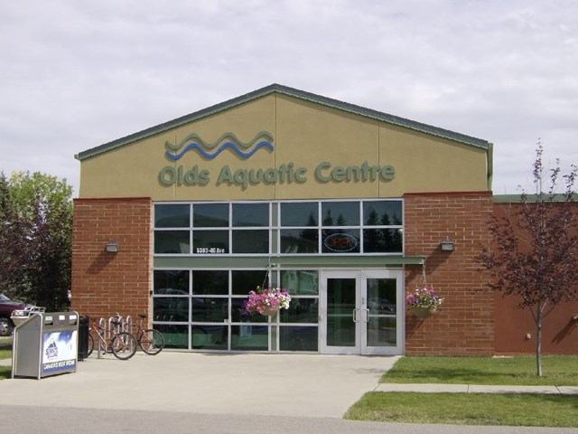 Brick and glass building with flower baskets.