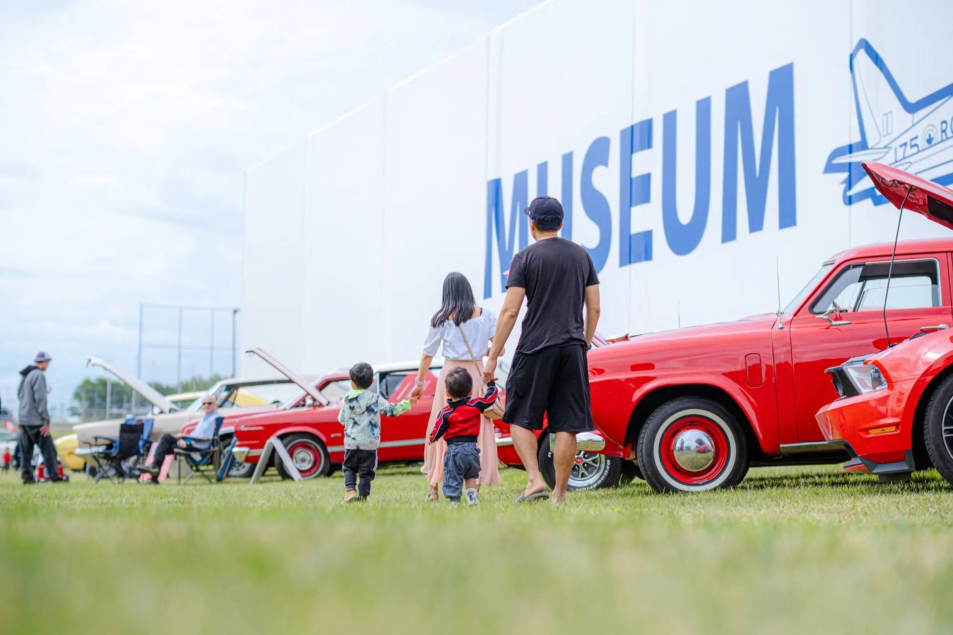 A family viewing the antique cars at the event.
