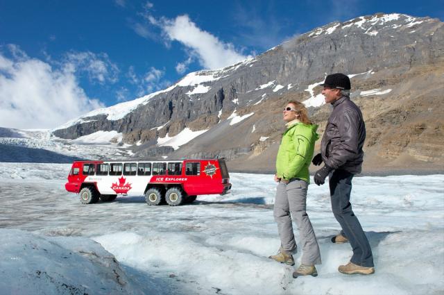 Couple on a group tour standing on Athabasca Glacier.