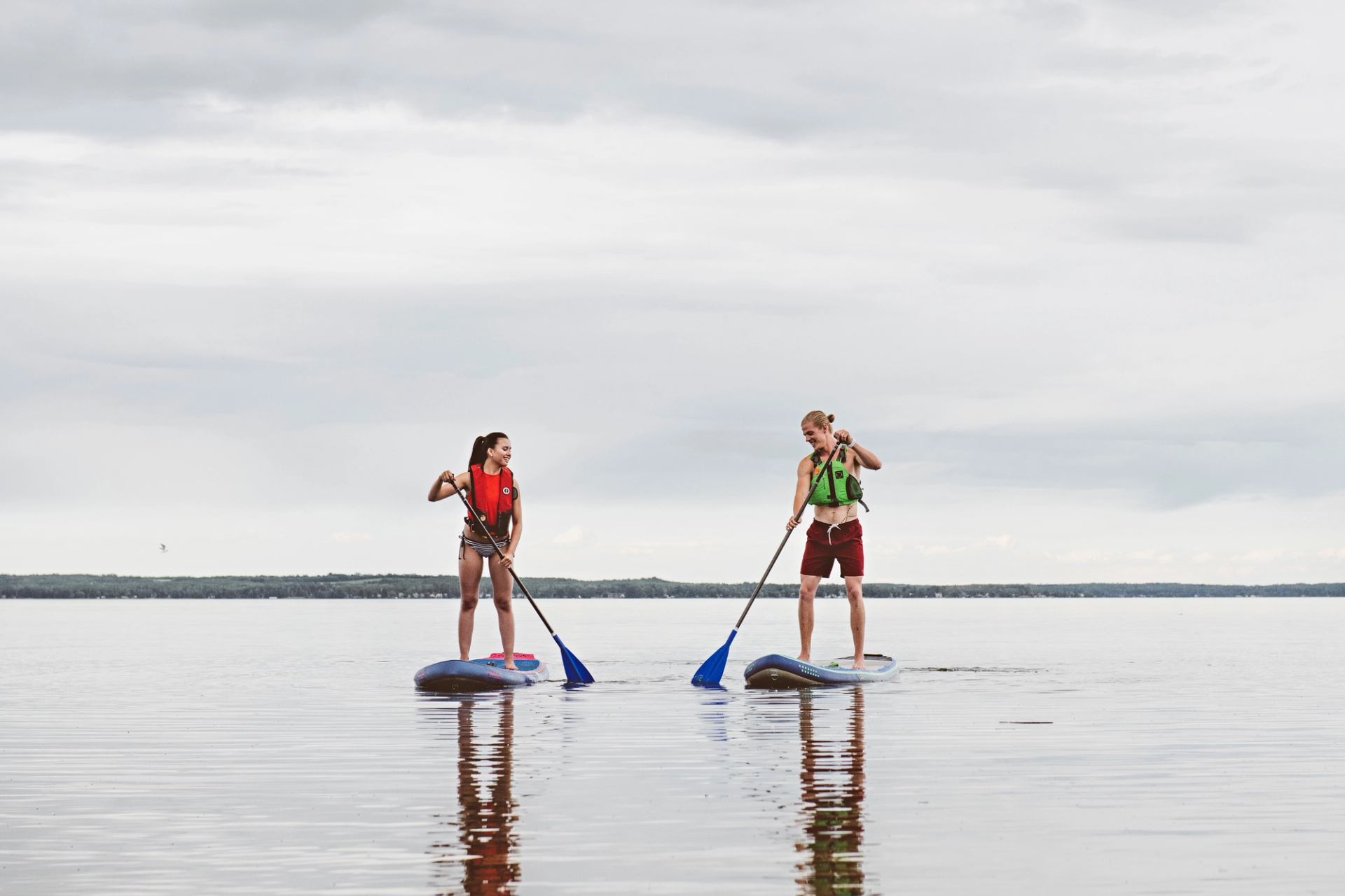Couple paddle boarding on Pigeon Lake.