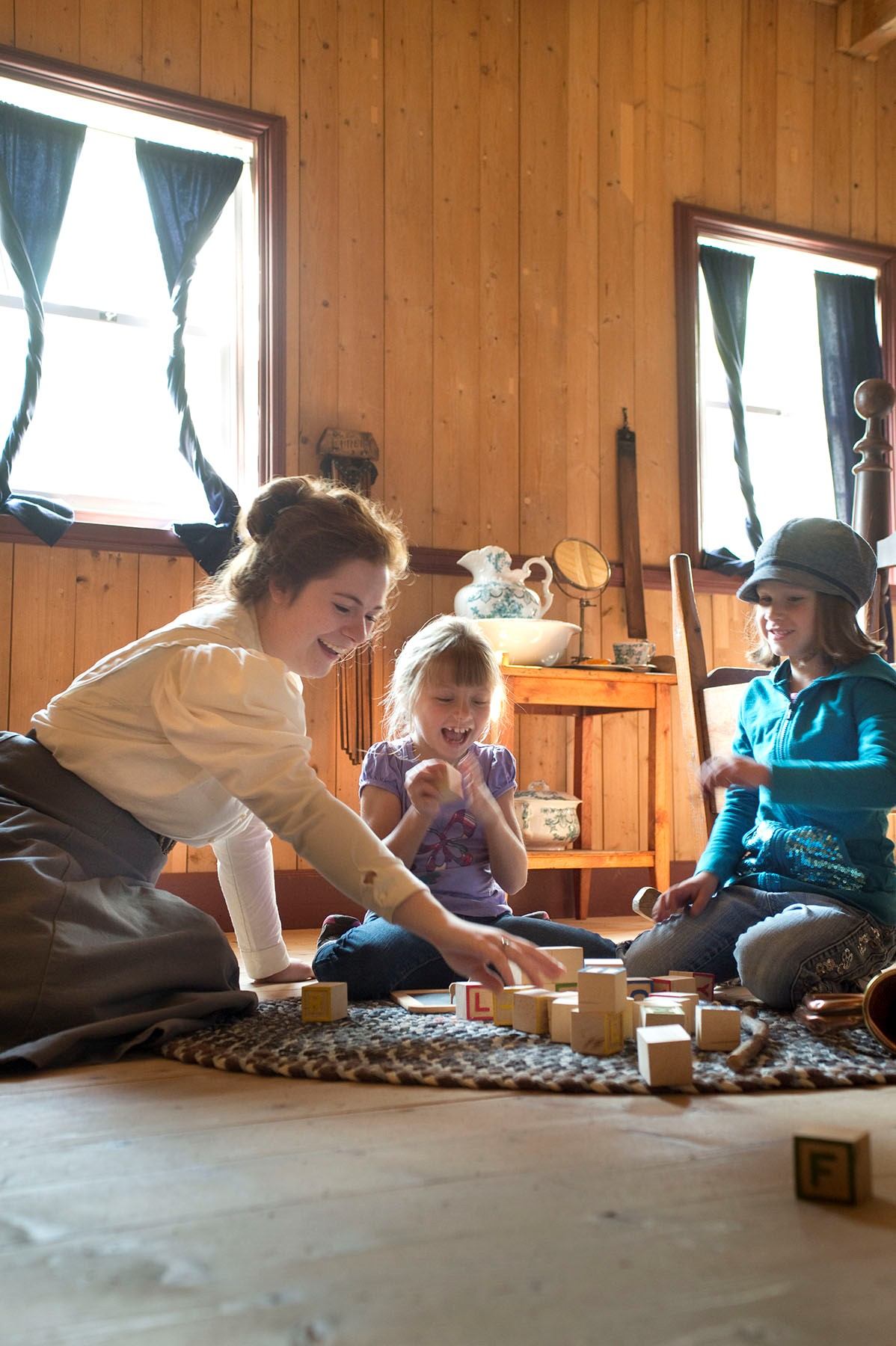 Children playing a historic game indoors at Historic Dunvegan.