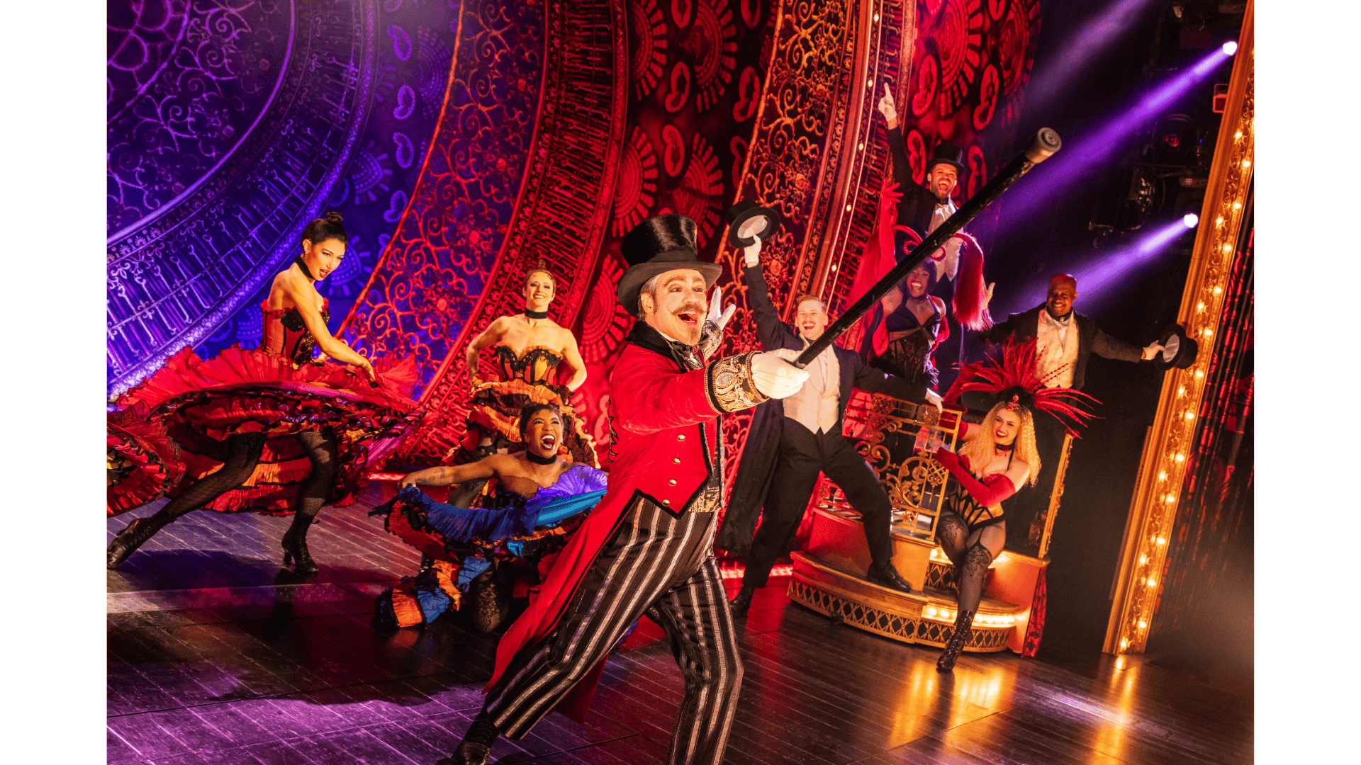 Stage performers in costumes under bright lights, with ornate red and purple backdrop.
