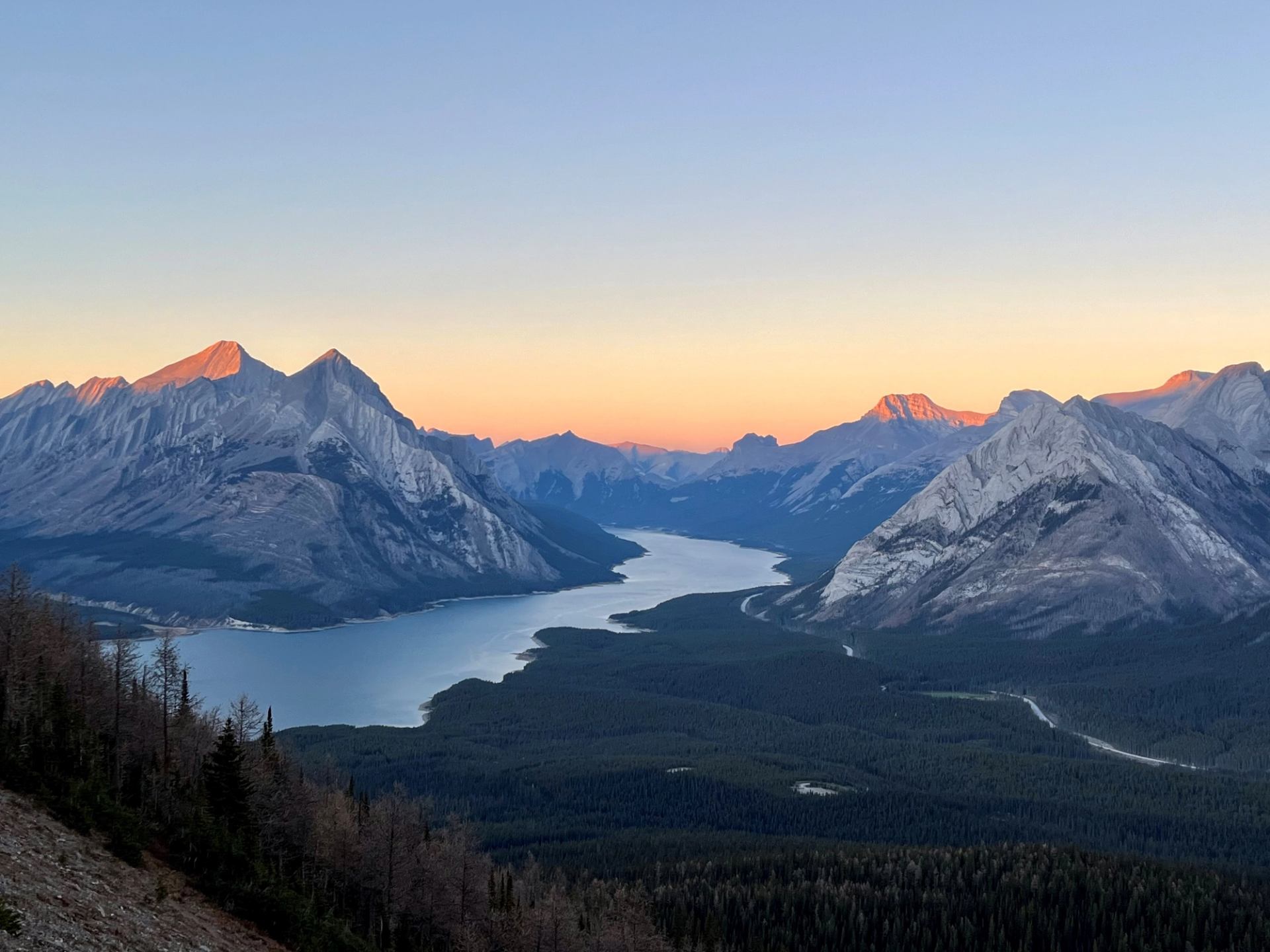Mountain valley with lake at sunrise or sunset.