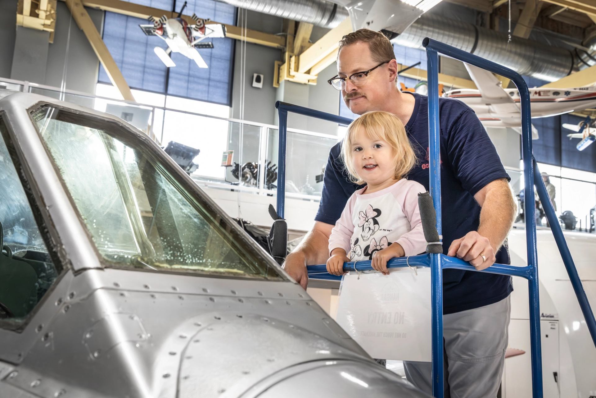 Father and daughter look into airplane cockpit display