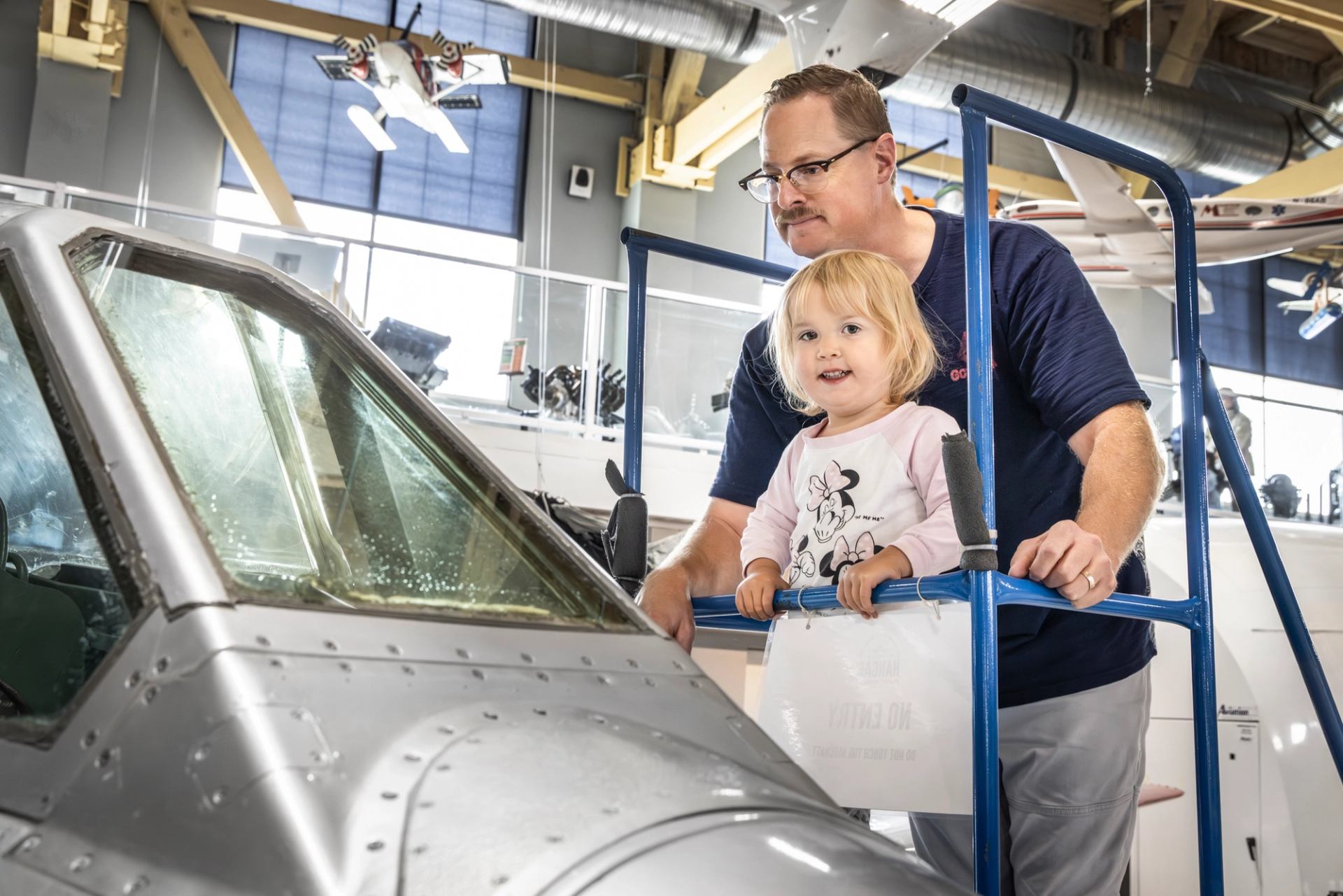 Father and daughter look into airplane cockpit display
