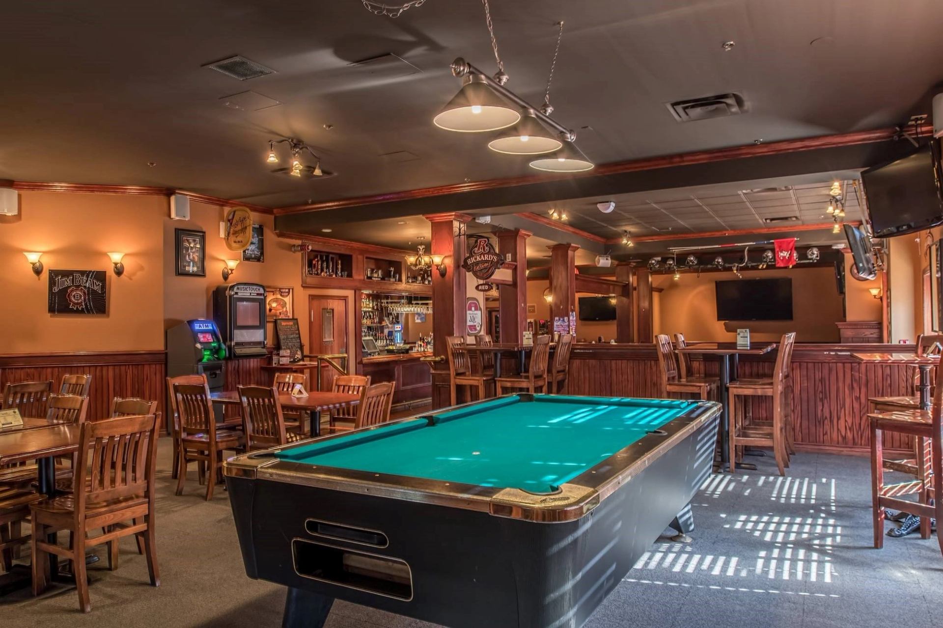 Cozy bar with pool table, wooden furniture, and warm lighting at Four Points by Sheraton.