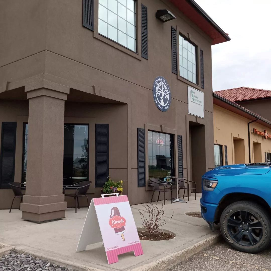 Exterior of shop with signage, boba ad, and large windows.