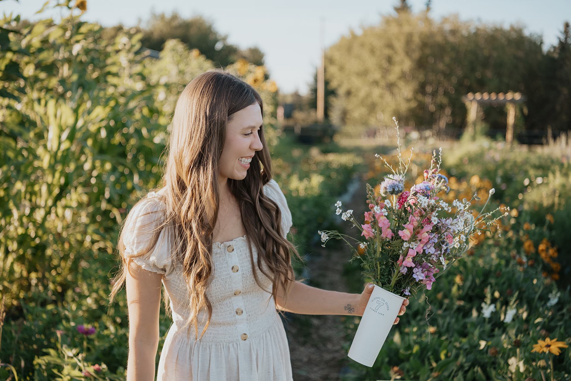 Person holding a bouquet of wildflowers while standing in a flower field at Blooms on 7 Flower Farm.
