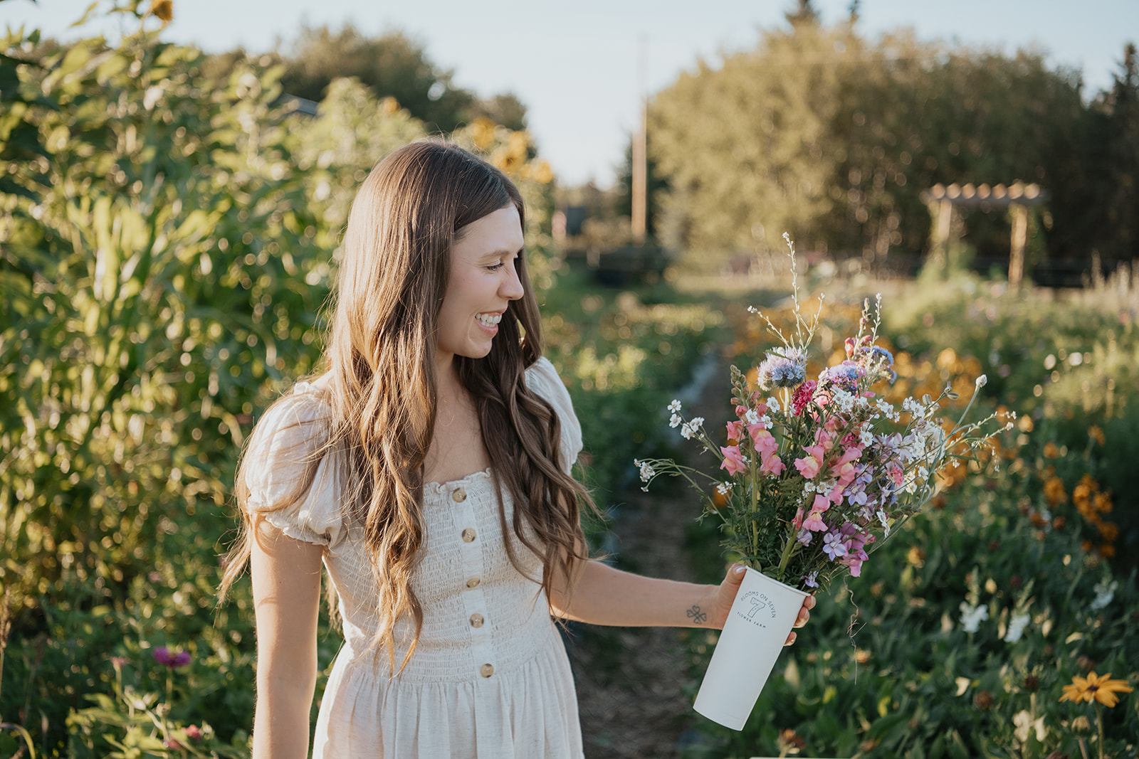 Person holding a bouquet of wildflowers while standing in a flower field at Blooms on 7 Flower Farm.