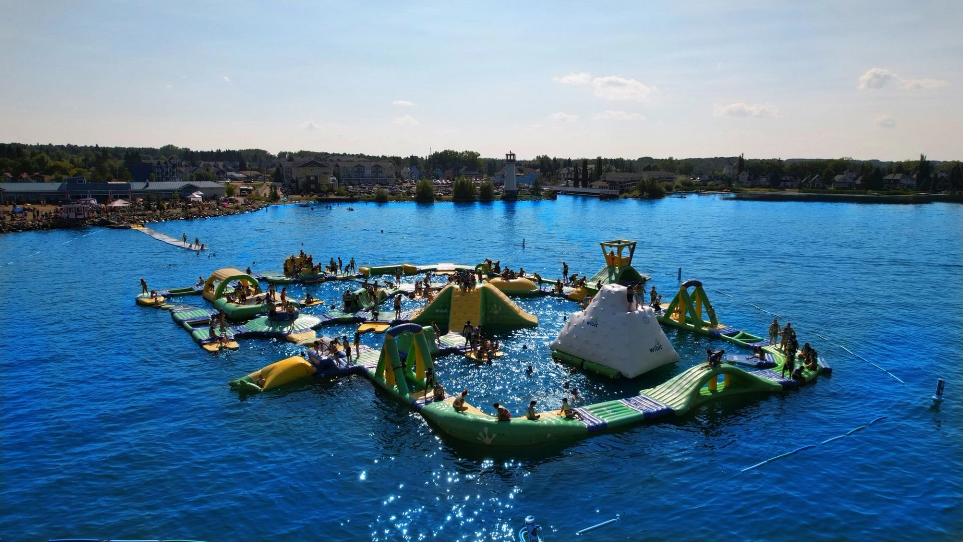 A large inflatable water park filled with people on the lake.