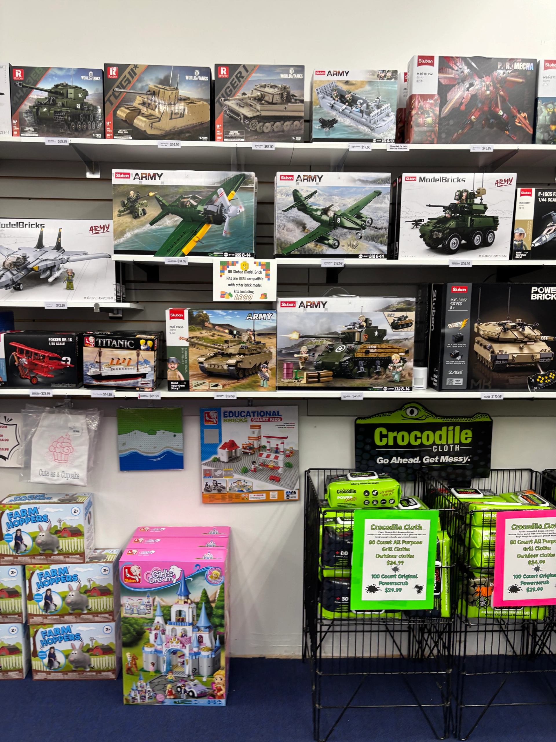 Store display of construction sets, model kits, educational toys, and activity cloths arranged on shelves.